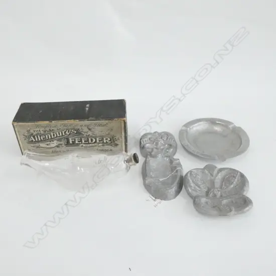 THREE PEWTER ASHTRAYS; 2 TIKIS, (LONGEST L. 165MM)1 SINGAPORE & BOXED GLASS FEEDER BOTTLE
