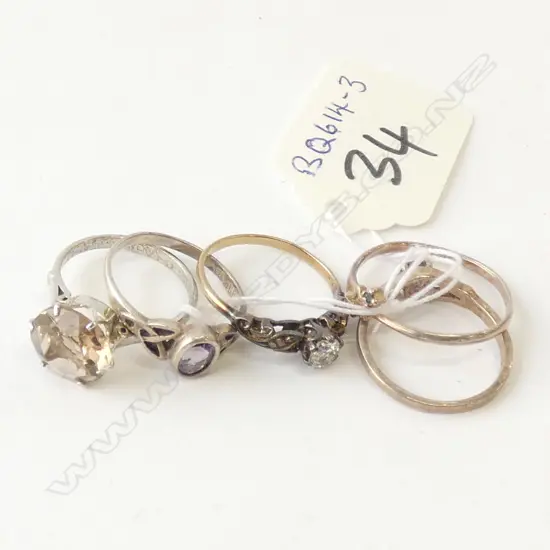 FOUR SILVER RINGS AND A GOLD RING