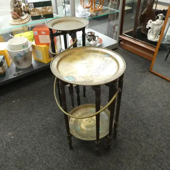 TWO BRASS TOP FOLDING TRAY TABLES (ONE REQUIRES MINOR REPAIR)