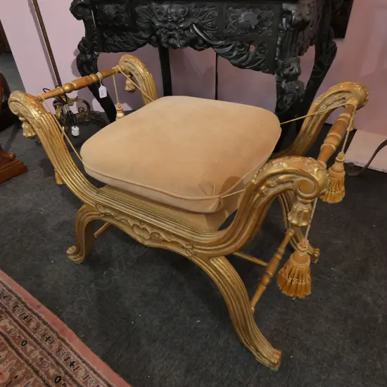 An ornate gilt curule stool