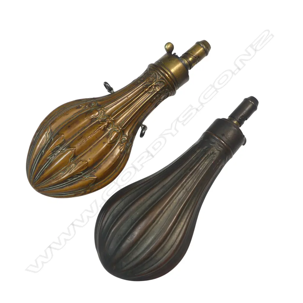 Two copper and brass bag-shaped shot flasks, one by G & J W Hawksley  with graduated dispenser nozzle (2¼, 2½, 2¾ and 3 drams), decorated with a fluted and moulded acanthus and hop design. The other unnamed. Image 1++