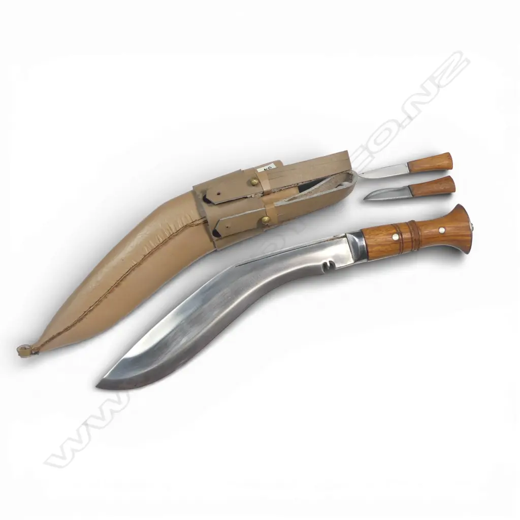 Contemporary Nepalese Khukri Knife, with heavy 11" blade, handle of Indian rose wood as are the handles on the small knives. Cream coloured leather scabbard with twin belt loops. Image 1++