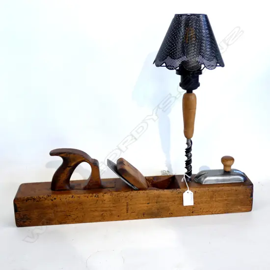 Old wooden plane 550mm long industrial shade and a rustic drill bit repurposed into an artisan lamp. Switch hidden under a breast drill cover and handle to form a weird and robust switch. Fitted with 12V 6W energy saving filament LED bulb with more than 25