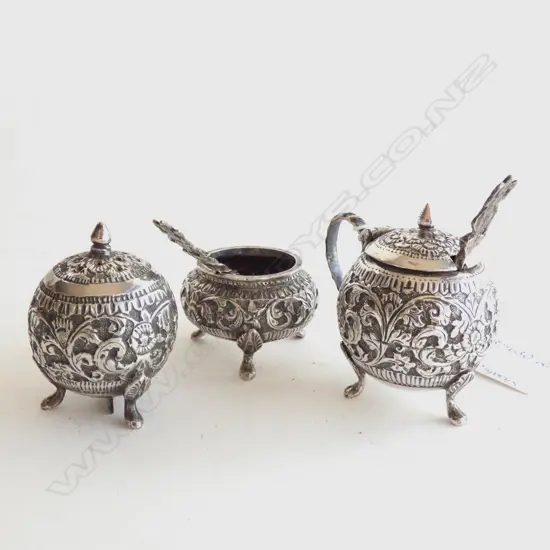 ORNATE FOOTED SILVER PLATE CRUET SET; PEPPER SHAKER / SALT DISH & SPOON / MUSTARD POT & SPOON H. 