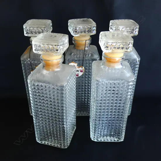 FIVE IDENTICAL CUT GLASS DECANTERS; 3 WITH TAGS H. 245MM
