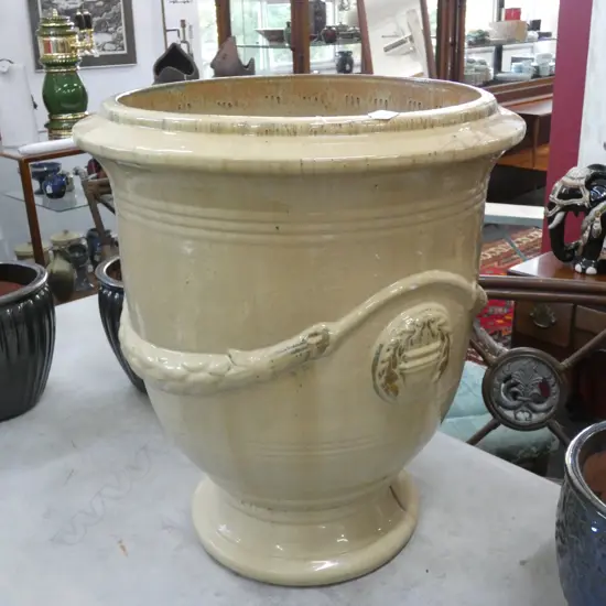 A LARGE TERRACOTTA GLAZED GARDEN URN WITH FRENCH STYLE SWAG DECORATION LARGE CHIP TO EDGE H 700MM W 600MM