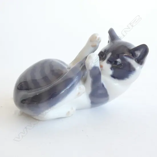 A ROYAL COPENHAGEN CAT, LYING ON BACK, PLAYING WITH TAIL. L.100mm