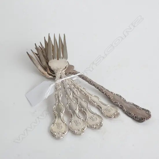 FOUR SILVER PLATE CAKE FORKS AND A LARGER SILVER CAKE FORK