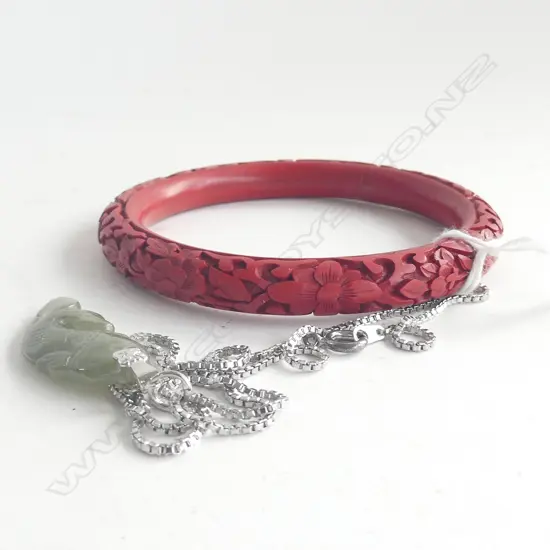 CARVED CINNEBAR LACQUER BANGLE AND CARVED JADE FISH ON WHITE METAL CHAIN