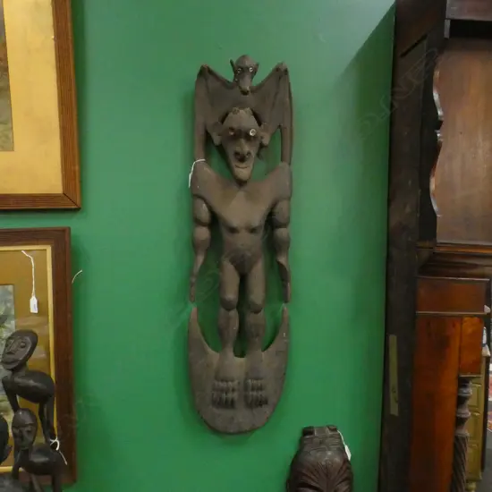 PNG CARVED WOOD FIGURAL FOOD HOOK SURMOUNTED BY A BAT. H.870mm