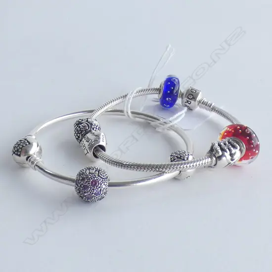 2 PANDORA BRACELETS WITH SOME SILVER BEADS
