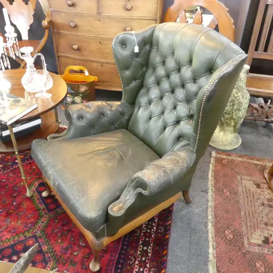 GREEN LEATHER WING BACK CHAIR SHOWING WEAR