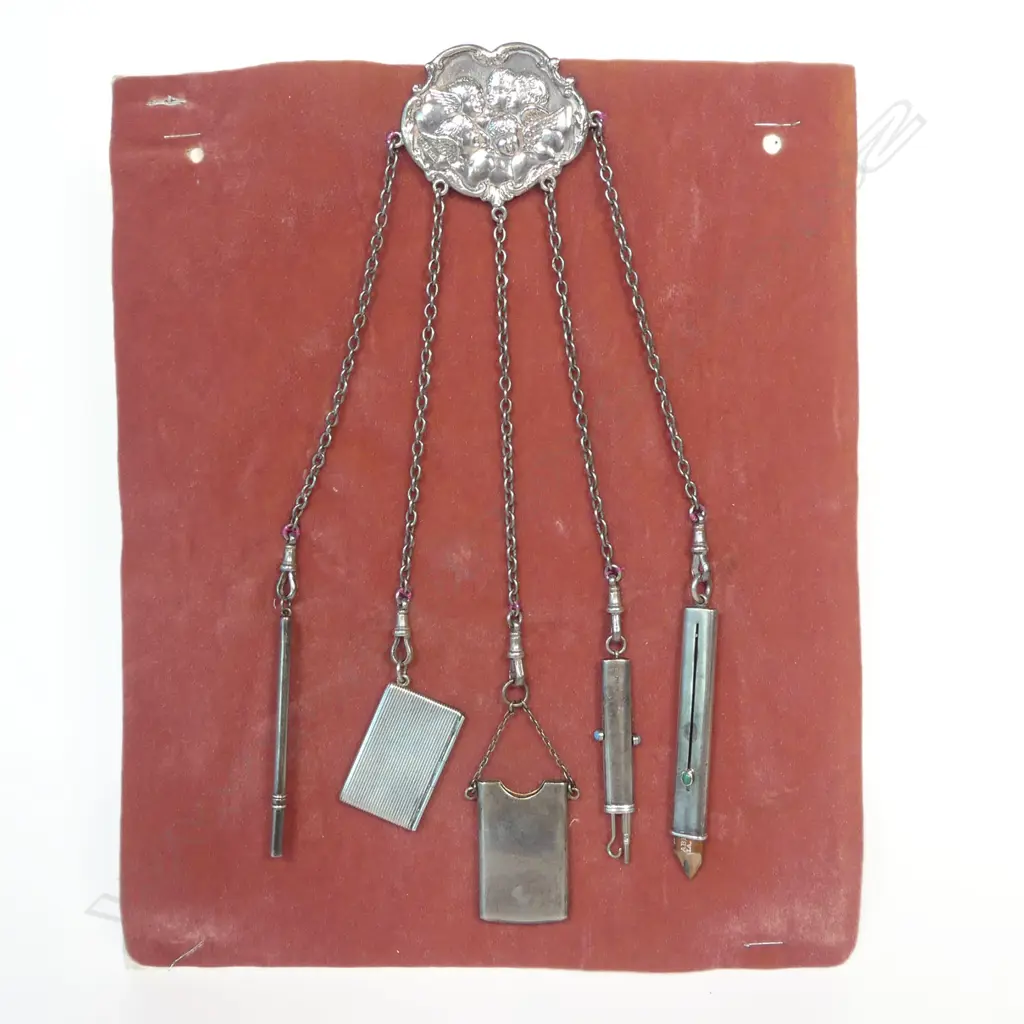 An Art Nouveau Angel's Heads sterling silver chatelaine with five suspended accoutrements, Birmingham 1900 by Henry Williamson Ltd., Image 1++