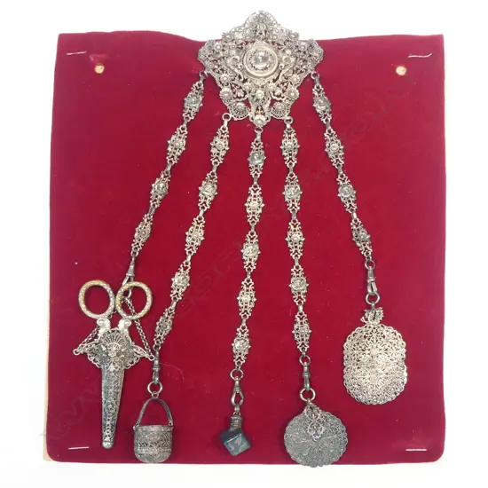 An unmarked possibly Continental silver chatelaine with five suspended accoutrements,