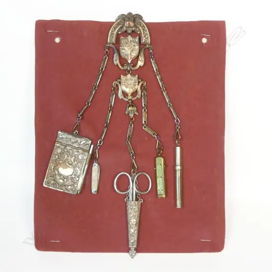 A late 19thC silvered copper chatelaine with five suspended accoutrements,