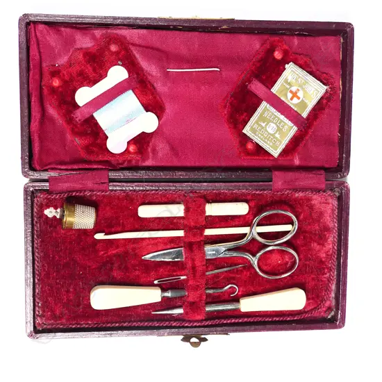 A red morocco cased sewing kit, with bone handled implements
