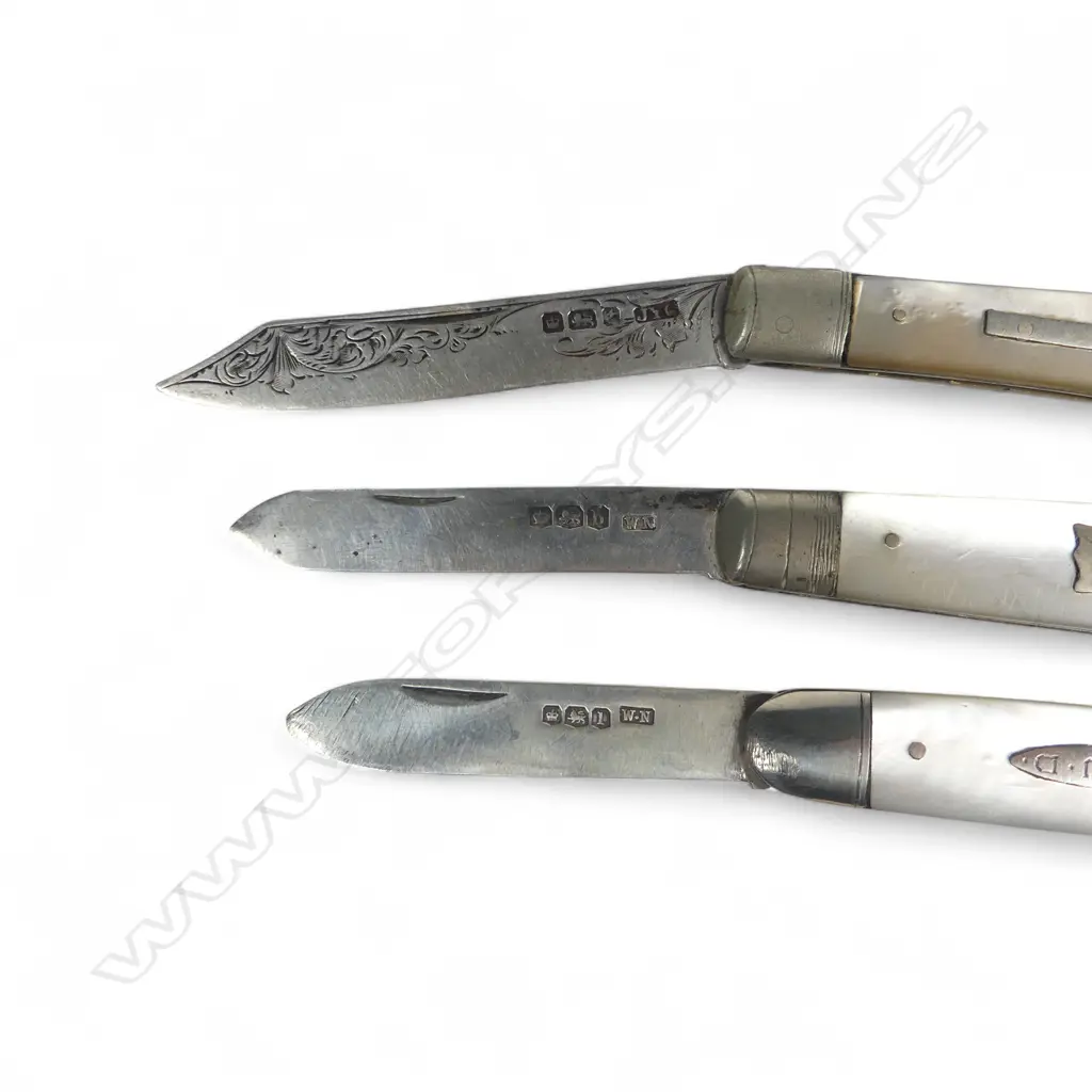 Three mother of pearl handled folding sterling silver bladed fruit knives, one of uncommon clipped shape. Various dates and makers. Image 1++