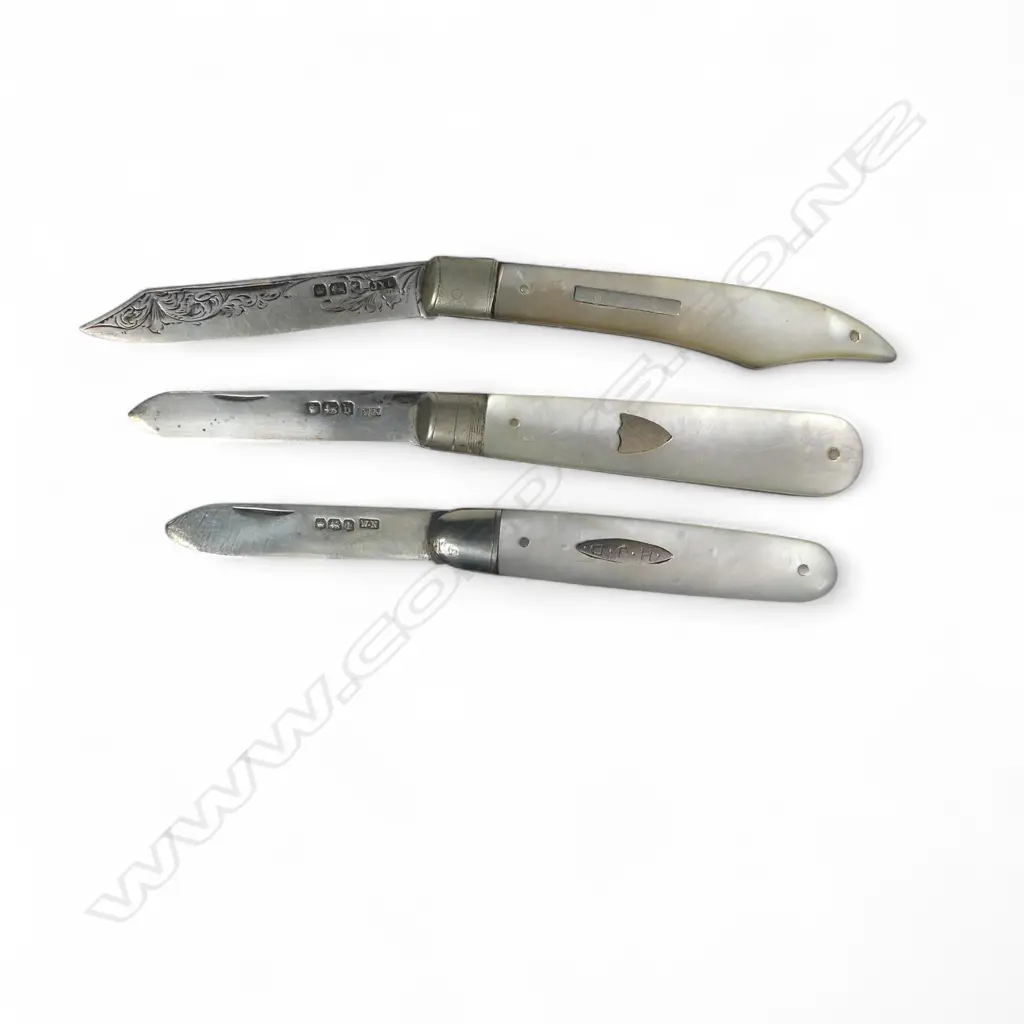 Three mother of pearl handled folding sterling silver bladed fruit knives, one of uncommon clipped shape. Various dates and makers. Image 1++