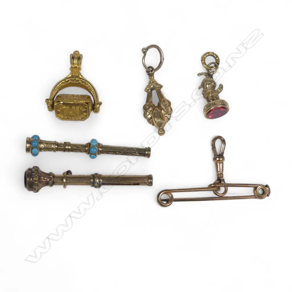 A collection of six small Victorian gold plated fob items and brooch pin hanger, including a swivel fob and mini telescopic pencils Image 1++