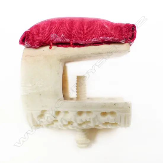 A Chinese carved ivory sewing work clamp with affixed pincushion and a bone Stanhope pincushion.