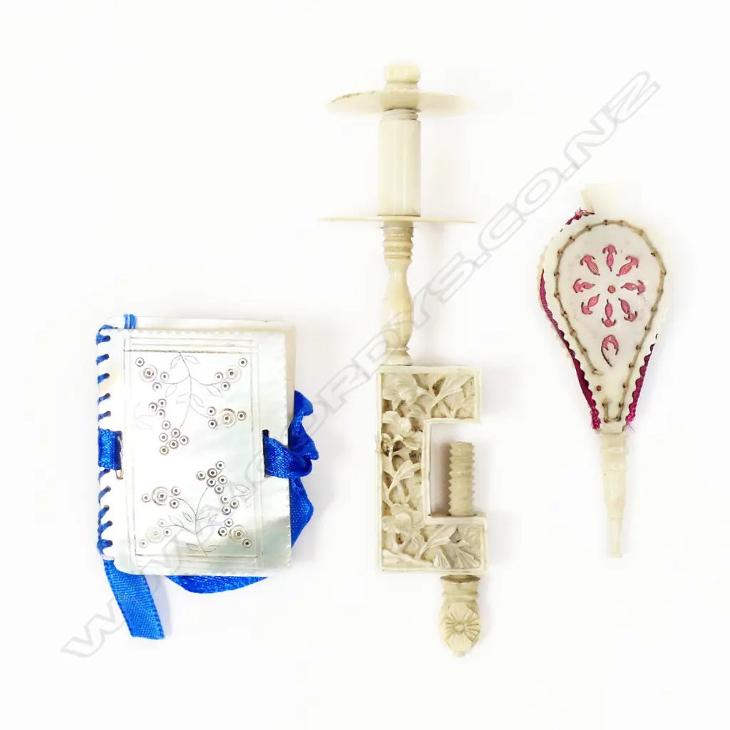 A Chinese carved ivory sewing clamp with bobbin spindle, a mother of pearl needle book and a pincushion shaped as miniature bellows, Image 1++