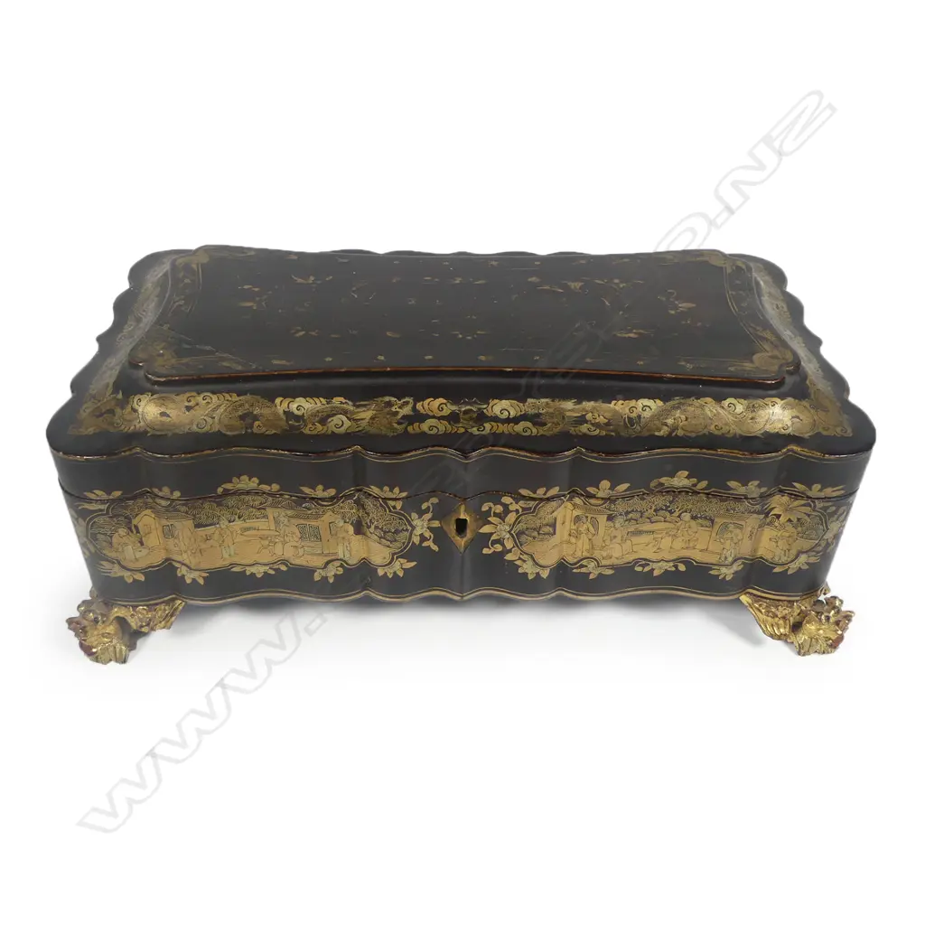 A Chinese export lacquer game box, early 19thC, on gilt wood dragon head legs with serpentine sides, rounded corners and hinged top, overall chinoiserie decoration in various shades of gold, the top considerably worn. Image 1++