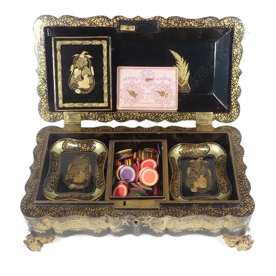 A Chinese export lacquer game box, early 19thC, on gilt wood dragon head legs with serpentine sides, rounded corners and hinged top, overall chinoiserie decoration in various shades of gold, the top considerably worn.