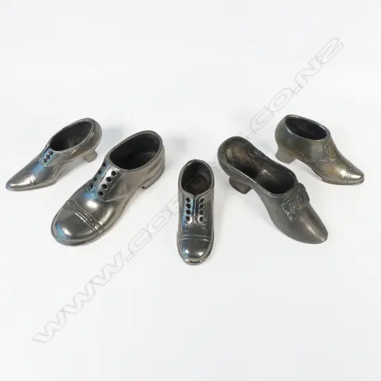 Five various metal shoe shaped pincushions