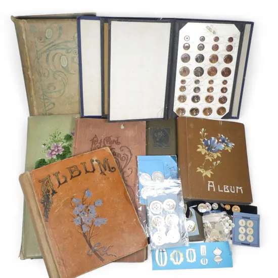 Six postcard album, mostly empty, a commercial sample album of button samples and a box of mother of pearl buttons and buckles.