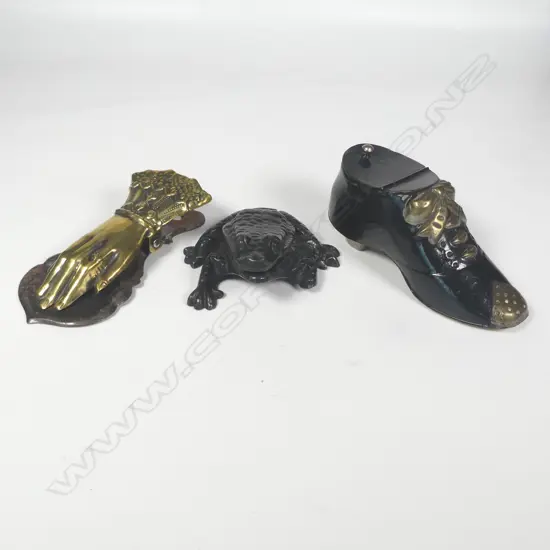 A cast iron frog table-top vesta, a Victorian brass hand paper clip and a black lacquered tin shoe vesta,