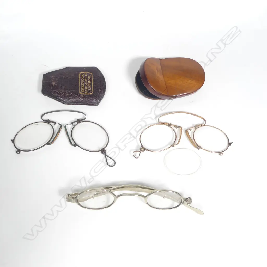 Two pair of folding C-spring pince nez, one gold plated in French wooden compact case, the other steel in optician named leather case, along with a pair of 'Pickwick' spectacles with telescoping arms Image 1++