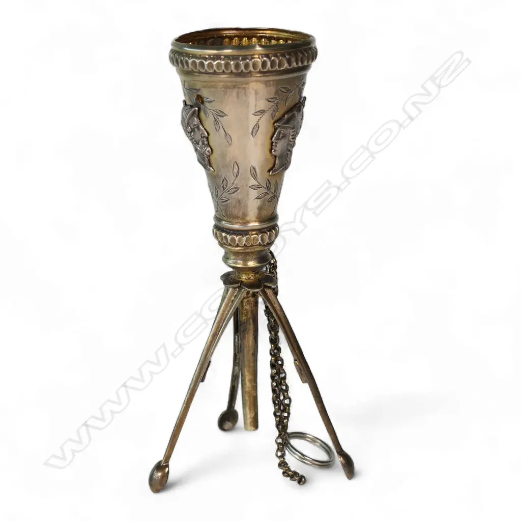 An uncommon unmarked silver posy holder, possibly French, conical with three applied classical busts, raised on three leaf spring activated folding legs. Image 1++