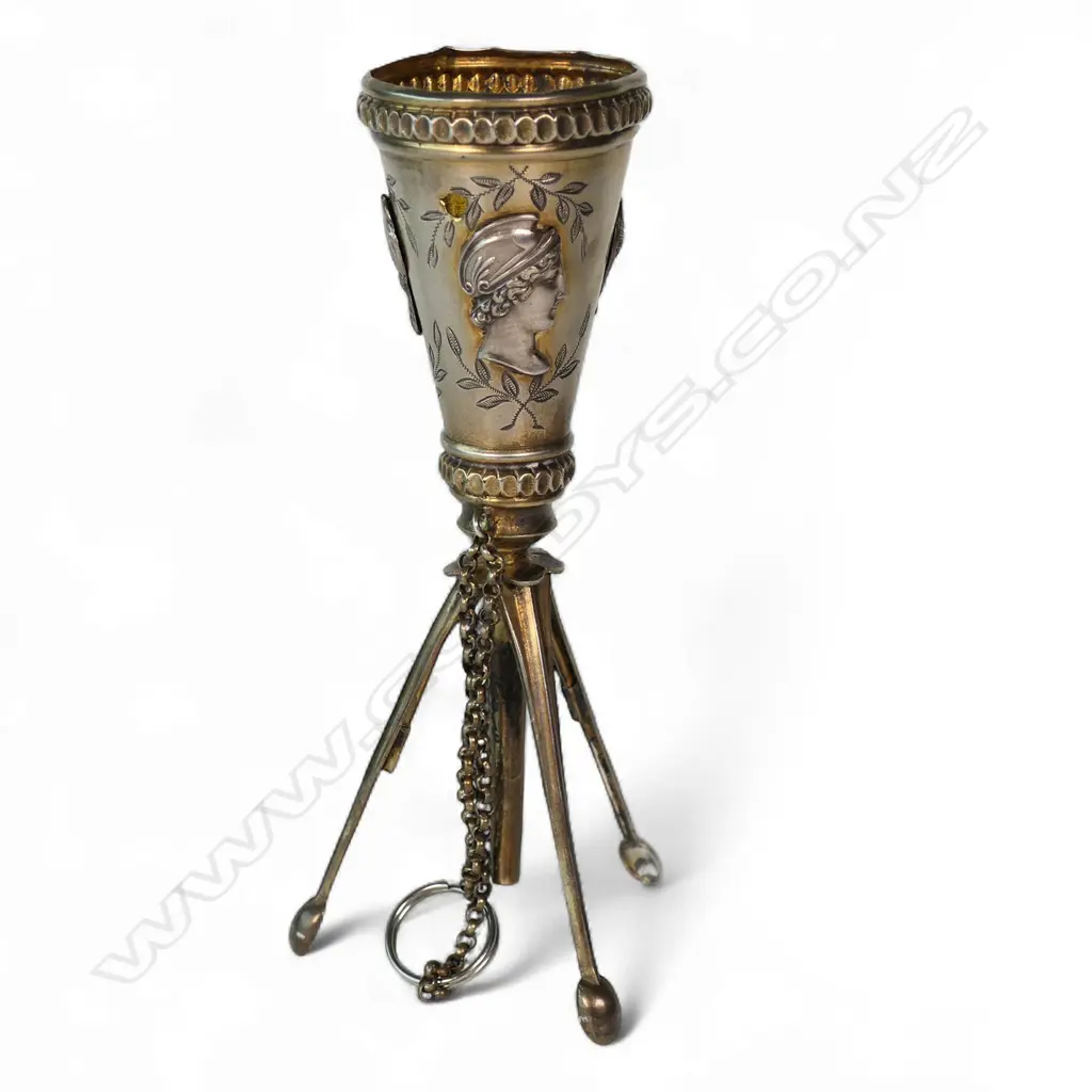 An uncommon unmarked silver posy holder, possibly French, conical with three applied classical busts, raised on three leaf spring activated folding legs. Image 1++