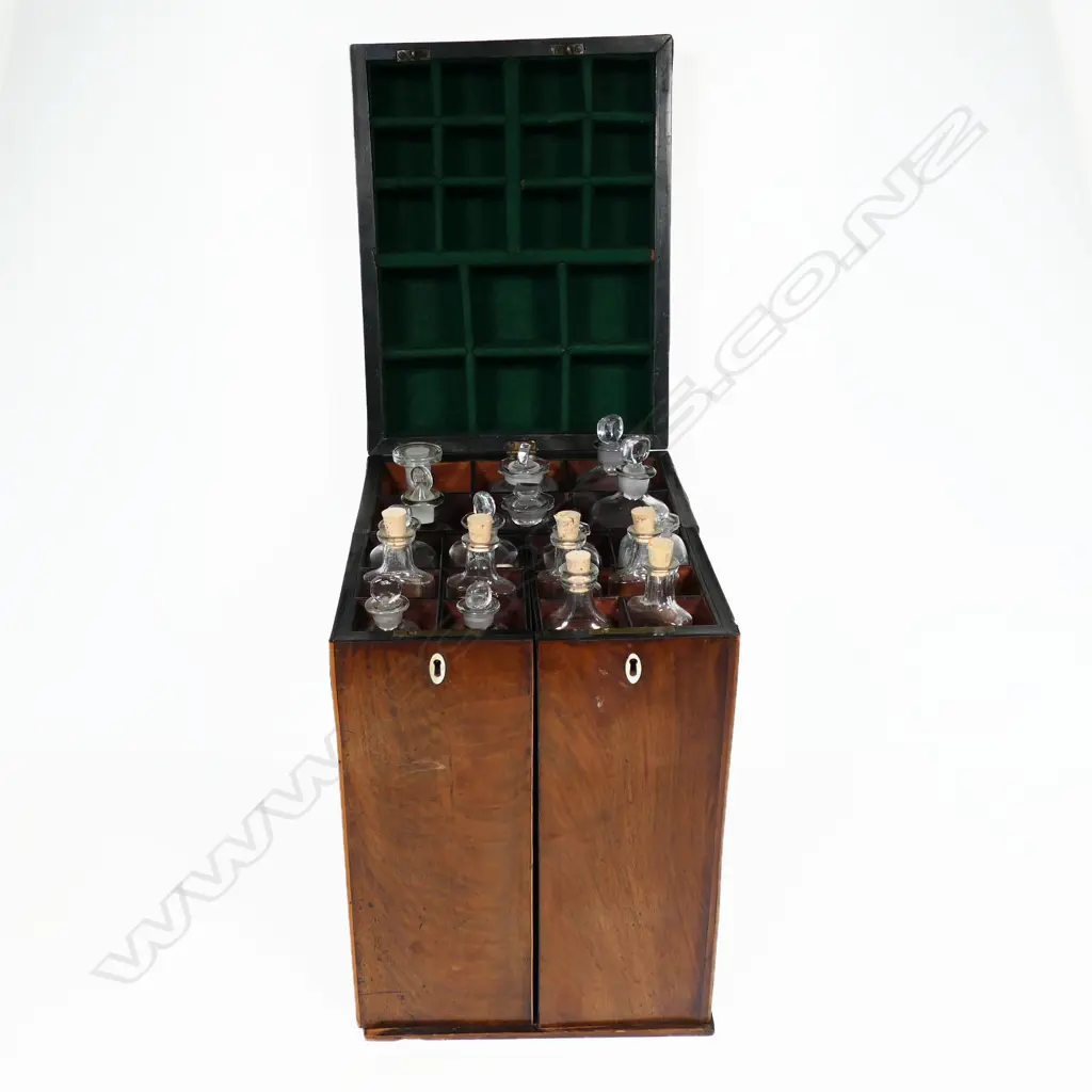 A George III period mahogany apothecary box, of tall oblong form with satinwood clashing and corners to the hinged lid, fitted with a stirrup handle. The front opening wing doors revealing an interior of 18 compartments and glass bottles, the front partitions pierced with Gothic openings to reveal the bottle labels, Image 1++