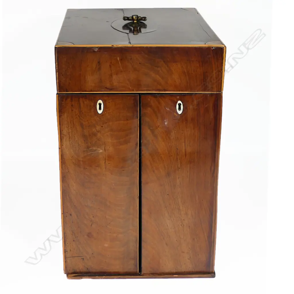 A George III period mahogany apothecary box, of tall oblong form with satinwood clashing and corners to the hinged lid, fitted with a stirrup handle. The front opening wing doors revealing an interior of 18 compartments and glass bottles, the front partitions pierced with Gothic openings to reveal the bottle labels, Image 1++