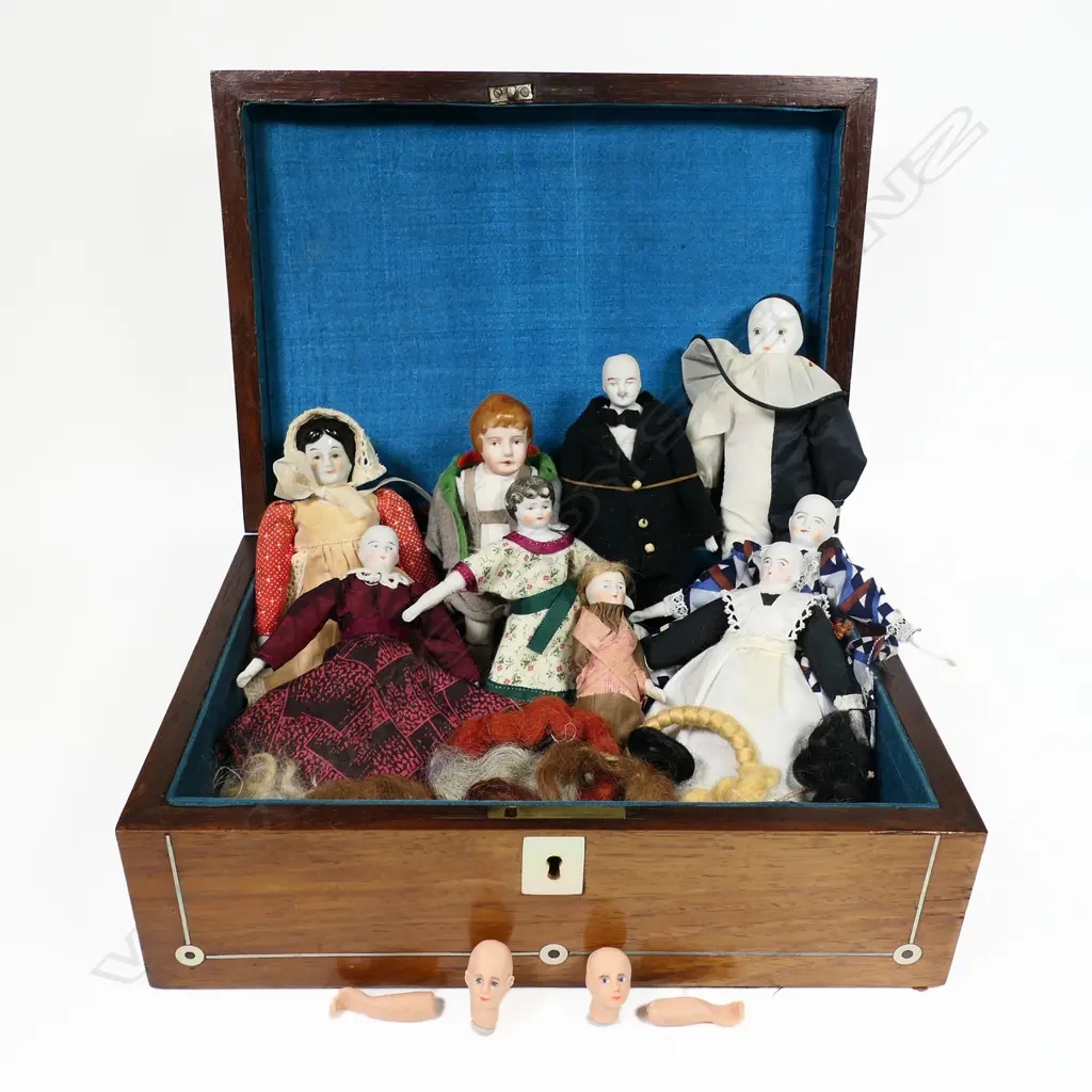 A late 19thC walnut workbox, inlaid with mother-of-pearl escutcheon, cartouche and rondels. Blue silk interior. With a collection of various doll's house dolls and parts. 280 x 200 x 100mm. Image 1++