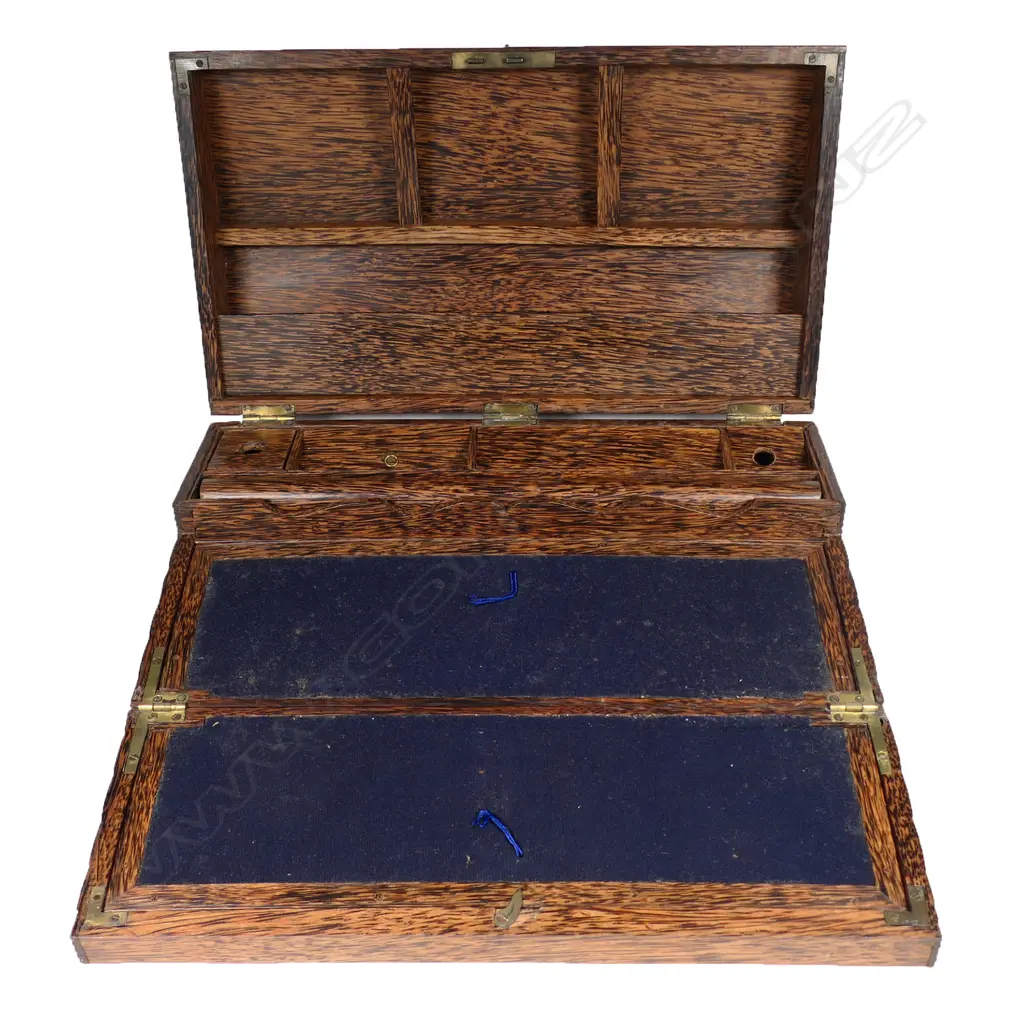 An early 20thC coconut palm wood writing slope, the lid opening to form a vertical stationery shelf, the front falling to make the slope. Variously partitioned, with one holding a rolling rule. The exterior walls and domed lid with small overall fluting. Image 1++