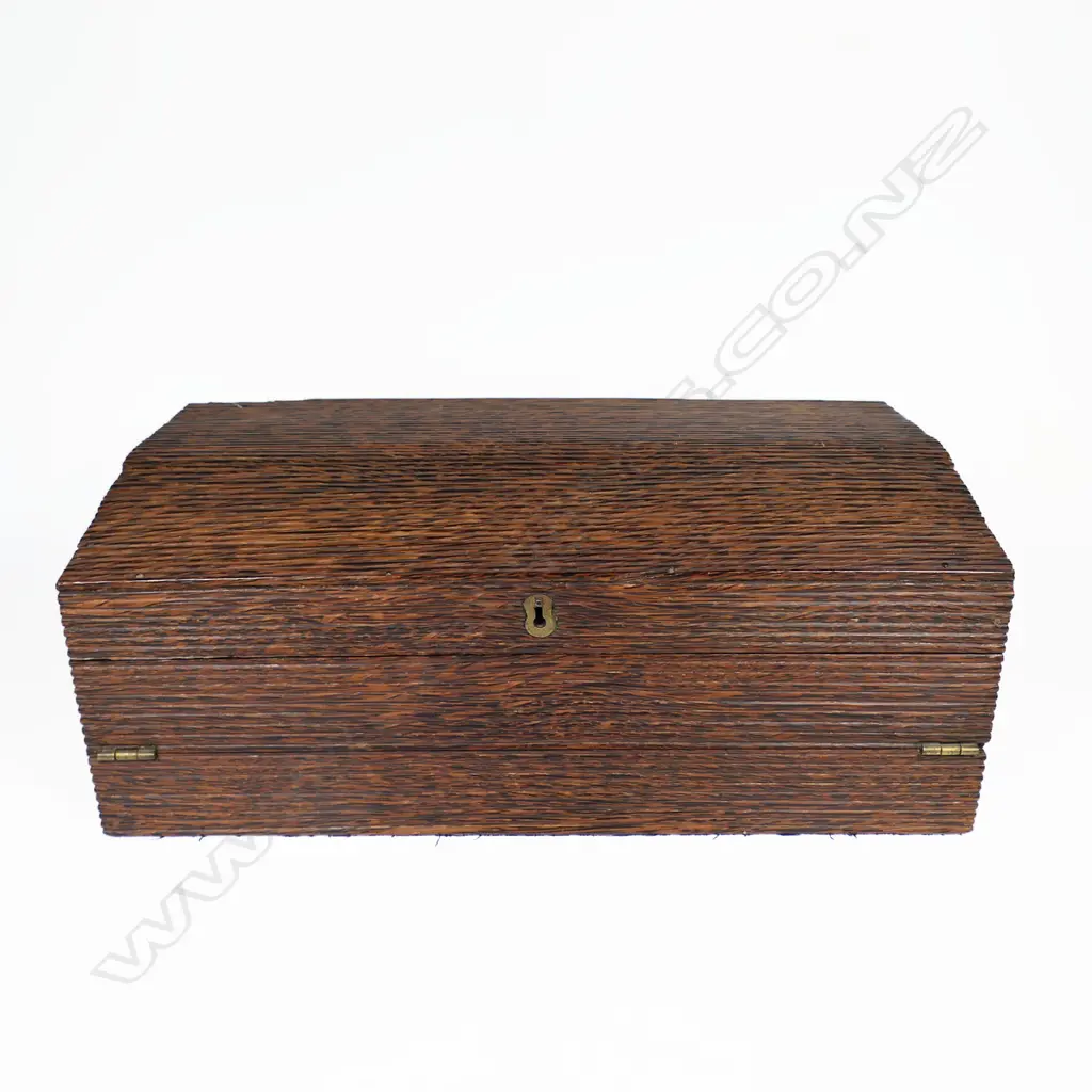 An early 20thC coconut palm wood writing slope, the lid opening to form a vertical stationery shelf, the front falling to make the slope. Variously partitioned, with one holding a rolling rule. The exterior walls and domed lid with small overall fluting. Image 1++