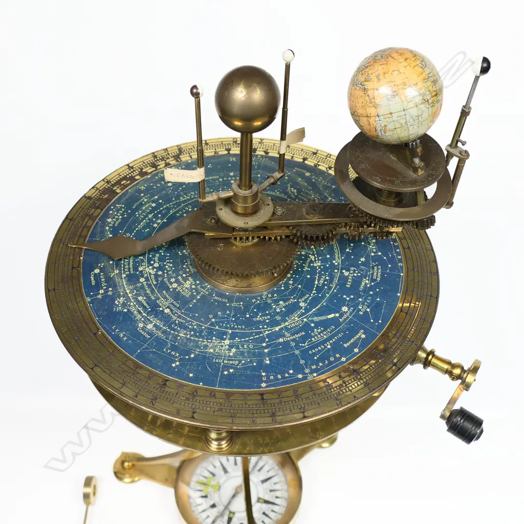 A 20thC brass drum top planetarium, the inner planets and sun raised above a plate with celestial map within an engraved calendar dial, Image 1++