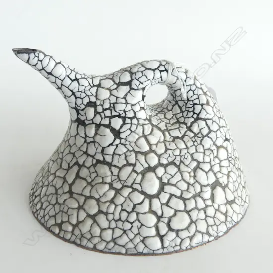 A Rick Rudd sculptured teapot with white over black "Crawlback" glaze of domed form with ring handle some chipping to front edge