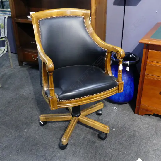 20THC LEATHER SWIVELLING TUB CHAIR. SCROLL ARMS WITH PILLAR SUPPORTS.