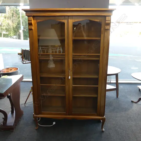 TALL WALNUT  TWO DOOR BOOKCASE. SOFT ARCHED GLAZED DOORS WITH PILLASTERS. ON CABRIOLE LEGS. H 1885mm