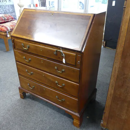 LATE GEORGIAN FALLFRONT BUREAU. MAHOGANY WITH TYPICAL STRINGING . 4 DRAWERS ON LATER OGEE FEET. H.1010 mm