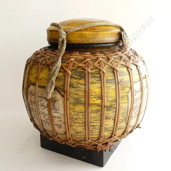 CANE COVERED LIDDED VESSEL. MADE IN THAILAND WITH THAI SCRIPT IN PANELS. LID ATTACHED BY ROPE. H.370 mm