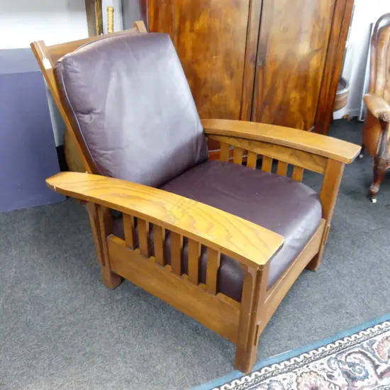 AN OAK FRAMED MORRIS STYLE CHAIR WITH LEATHER SEAT AND BACK 