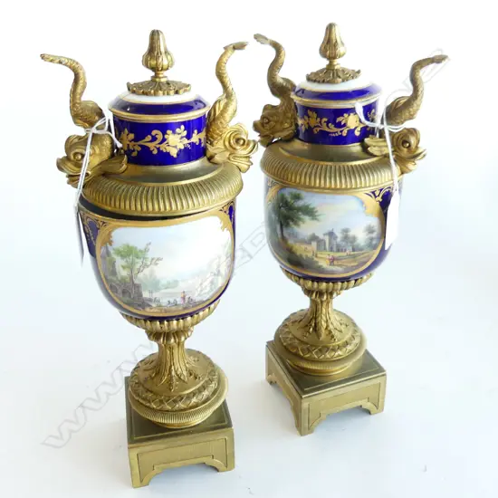 PAIR OF SEVRES HANDPAINTED ORMOLU MOUNTED LIDDED URNS. DOLPHIN DETAIL FLANKING THE LIDS (BOTH LIDS AF) . H.290mm