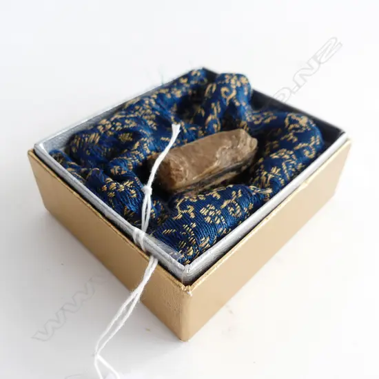 ANCIENT BUDDHISTIC? SHAPED STONE RELIC IN A FITTED FABRIC SLEEVE OF UNKNOWN MATERIAL WHICH HAS WAVY STRIPS OF ......