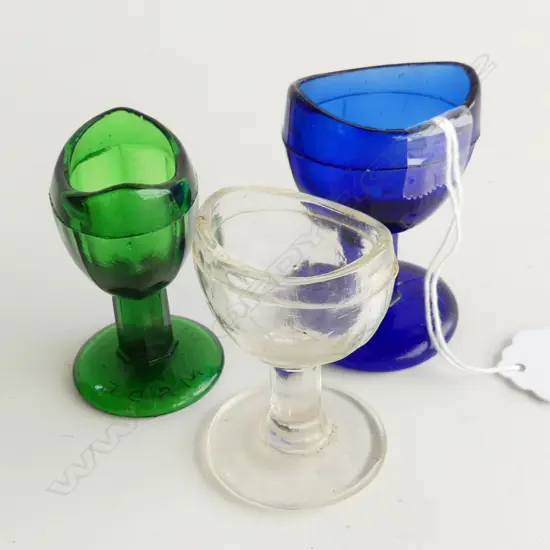 THREE VINTAGE GLASS EYE BATHS GREEN, COBALT BLUE AND CLEAR H. 6MMM, H. 60MM