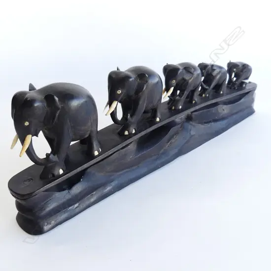 FIVE EBONY ELEPHANTS ON INTEGRATED STAND. L.370mm H. 130mm . SOME TUSK DAMAGE.