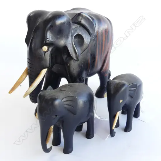 THREE EBONY ELEPHANTS. LARGEST WITH BROWN ACCENTS H.150mm SMALLEST 75mm . SOME TUSK DAMAGE.